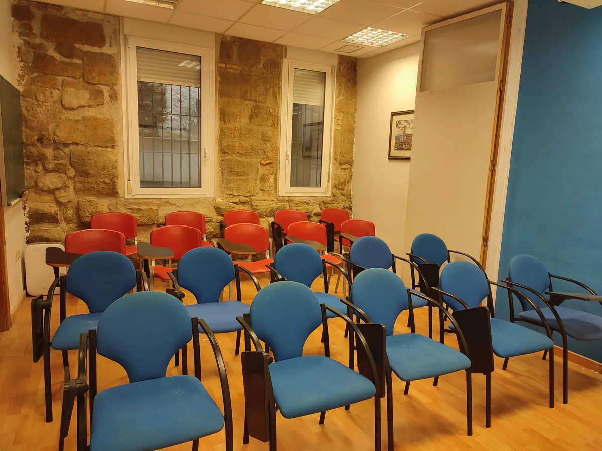 Aula de alquiler preparada en formato conferencia, con sillas de pala
